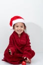 Girl holding a red christmas ball in sweater and santa hat Royalty Free Stock Photo