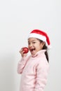 Girl holding a red christmas ball in sweater and santa hat Royalty Free Stock Photo