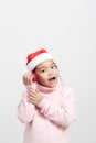 Girl holding a red christmas ball in sweater and santa hat Royalty Free Stock Photo