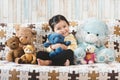 Cute little asian girl hugging her plush toy teddy bear on a sofa. Royalty Free Stock Photo