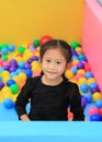 Cute little Asian girl playing in a kids` ball pit at a playground Royalty Free Stock Photo