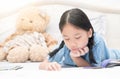 Cute little asian girl reading fairy tales on bed Royalty Free Stock Photo