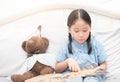 Cute little asian girl reading fairy tales book on bed Royalty Free Stock Photo