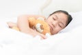 Cute little asian girl sleep and hug teddy bear on bed Royalty Free Stock Photo