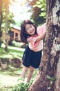 Cute little asian girl under big tree outdoor in the park Royalty Free Stock Photo