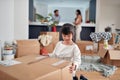 Cute little asian girl unpacking box with her toys with her parents in the background Royalty Free Stock Photo