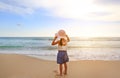 Cute little asian girl wear straw hat walking on the beach with looking out to the sea Royalty Free Stock Photo