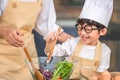 Cute little Asian happy boy interested in cooking with mother funny in home kitchen. People lifestyles and Family. Homemade food Royalty Free Stock Photo