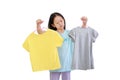 Cute little asian kid girl trying to decide between two shirt on white background Royalty Free Stock Photo