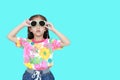 Cute little Asian kid girl wearing a flowers summer dress and sunglasses  on cyan background with copy space. Summer and Royalty Free Stock Photo