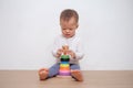 Asian 18 months / 1 year old toddler baby boy child play with colorful wooden pyramid toy / stacking ring toy