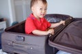 Cute little Asian toddler baby boy child sitting in travel suitcase getting ready for vacation, Kid playing in traveling baggage Royalty Free Stock Photo