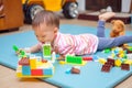 Cute little Asian 18 months / 1 year old toddler boy child having fun playing with colorful building blocks indoor he lay down and Royalty Free Stock Photo