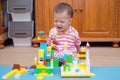 Cute little Asian 18 months / 1 year old toddler boy child having fun playing with colorful building blocks indoor in w-sitting po Royalty Free Stock Photo