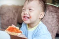 Cute little Asian 30 months / 2 years old toddler baby boy child biting & eating toast as breakfast Royalty Free Stock Photo