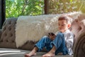 Cute Little Asian Thai Boy Sitting and Watching Mobile Phone