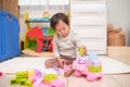 Cute little Asian toddler girl child having fun playing with colorful plastic toy blocks on floor at home, Educational toys for Royalty Free Stock Photo