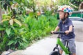 Asian 2 years / 30 months old baby boy child wearing safety helmet learning to ride first balance bike in sunny summer day Royalty Free Stock Photo