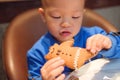 Cute little Asian 2 years old toddler baby boy child eating Gingerbread Man