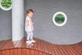 Cute little Asian toddler baby boy child having fun walking on wooden playground equipment in the park, Motor Skills development Royalty Free Stock Photo