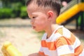 Cute little Asian 2 - 3 years old toddler boy child sweating during having fun playing, exercising outdoor at playground, Heat Royalty Free Stock Photo