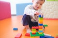 Cute little Asian 2 - 3 years old toddler boy child having fun playing with colorful plastic blocks indoor at play school / nurser Royalty Free Stock Photo