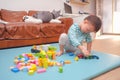 Asian 2 - 3 years old toddler boy child having fun playing with wooden building block toys indoor at home Royalty Free Stock Photo