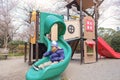 Cute little Asian 2 -3 years old toddler boy child playing on a slide in playground with sakura cherry blossom in Japan Royalty Free Stock Photo