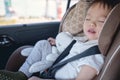 Cute little Asian 2 - 3 years toddler baby boy child sleeping in modern car seat. Child traveling safety on the road Royalty Free Stock Photo