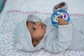 Little asin baby boy lying on soft blanket and play toy