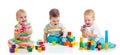 Cute little babies playing with toys or blocks and having fun while sitting on floor isolated over white background Royalty Free Stock Photo