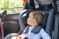 Cute little baby boy in car safety seat looking at the window. Royalty Free Stock Photo