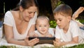 Cute little baby boy with family lying on grass in park with tablet computer. Parenting, family, children development Royalty Free Stock Photo