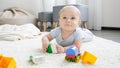 Cute little baby boy lying on carpet in living room and smiling. Concept of children development, education and Royalty Free Stock Photo