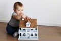 Cute little baby boy playing with small wooden house Royalty Free Stock Photo