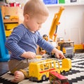 Cute little baby boy playing with toy school bus in his room. Indoors activities with children. Child playing in kid`s room Royalty Free Stock Photo