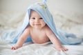 Cute little baby boy, relaxing in bed after bath, smiling happily Royalty Free Stock Photo