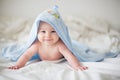 Cute little baby boy, relaxing in bed after bath, smiling happily Royalty Free Stock Photo