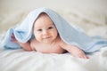 Cute little baby boy, relaxing in bed after bath, smiling happily Royalty Free Stock Photo