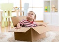 Cute little baby boy sitting inside cardboard box, moving out concept Royalty Free Stock Photo