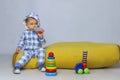 Cute Little Baby Boy Sitting On a Yellow Bean Bag Chair and Playing Toys. Royalty Free Stock Photo