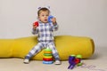 Cute Little Baby Boy Sitting On a Yellow Bean Bag Chair and Playing Toys. Royalty Free Stock Photo