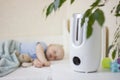 Cute little baby boy sleeping in bedroom with air humidifier. Royalty Free Stock Photo