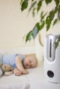 Cute little baby boy sleeping in bedroom with air humidifier. Royalty Free Stock Photo