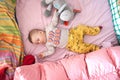 A cute little baby boy is sleeping peacefully and relaxed on his bed with toys Royalty Free Stock Photo