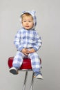 Cute Little Baby Boy Wearing On Sleepwear and Sitting On A Red Chair.