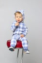 Cute Little Baby Boy Wearing On Sleepwear and Sitting On A Red Chair.