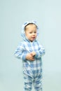 Cute little baby boy wearing on sleepwear standing in the room.