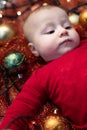 Cute little baby with colorful Christmas baubles