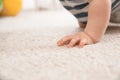 Cute little baby crawling on carpet indoors, closeup Royalty Free Stock Photo